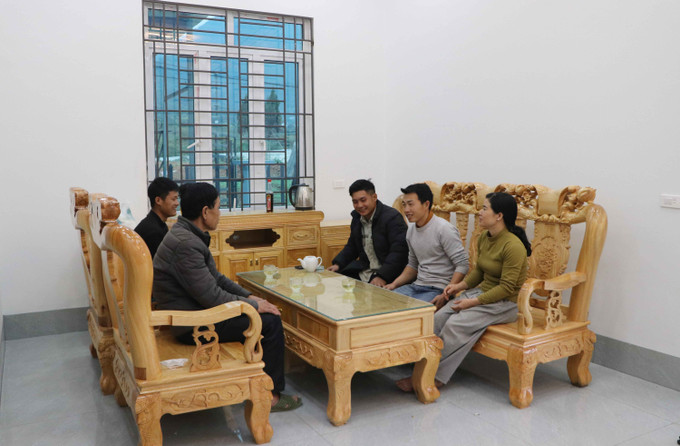 Gia đình anh Đèo Văn Tạ (áo xám) bản Hợp Nhất, xã Bản Bo (Lai Châu) vui mừng dọn vào ở ngôi nhà mới xây tại khu tái định cư.