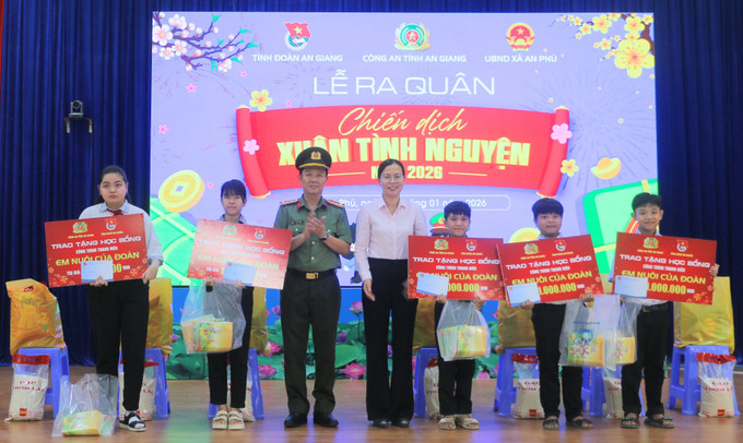Đại tá Lê Phú Thạnh, Phó Giám đốc Công an tỉnh An Giang (thứ 3 trái qua) và bà Quách Tố Giang, Bí thư Đảng uỷ xã An Phú trao bảng tượng trưng học bổng “Em nuôi của Đoàn” cho học sinh khuyết tật, có hoàn cảnh khó khăn trên địa bàn xã An Phú.