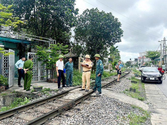 Lực lượng chức năng rà soát, xóa bỏ các điểm đi qua đường tàu tự phát ở TP Cẩm Phả. Ảnh: TTXVN phát quang-ninh-2.jpg