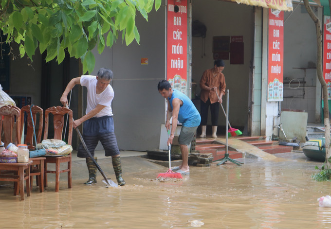 Người dân dọn dẹp bùn đất tại những nơi nước rút. Ảnh: Chu Hiệu/TTXVN Người dân dọn dẹp bùn đất tại những nơi nước rút. Ảnh: Chu Hiệu/TTXVN