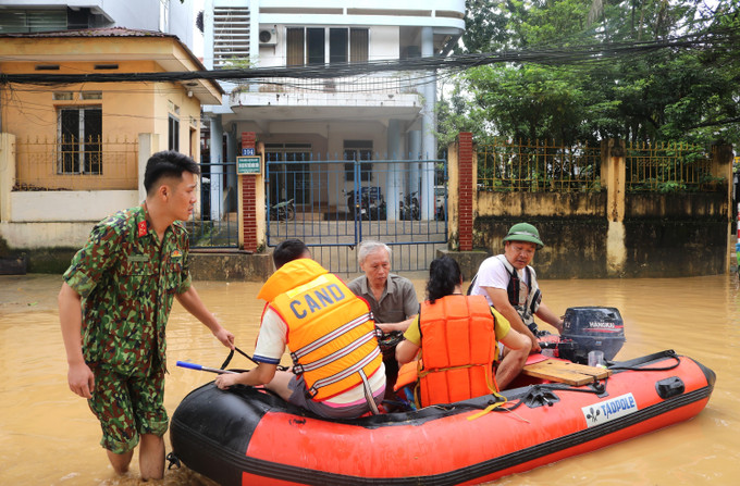 Lực lượng chức năng hỗ trợ người dân di chuyển trong vùng ngập lụt. Ảnh: Chu Hiệu/TTXVN cao-bang-7.jpg