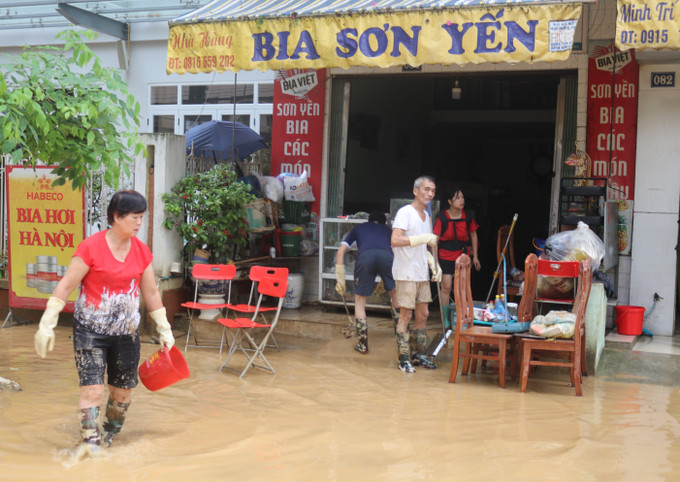 Người dân dọn dẹp bùn đất vào nhà do ngập lụt. Ảnh: Chu Hiệu/TTXVN Người dân dọn dẹp bùn đất vào nhà do ngập lụt. Ảnh: Chu Hiệu/TTXVN