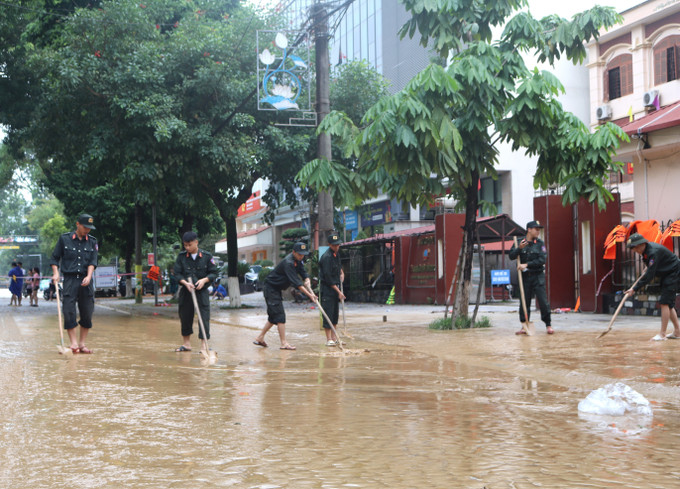 Lực lượng chức năng dọn dẹp bùn đất những đoạn đường phố nước đã rút. Ảnh: Chu Hiệu/TTXVN Lực lượng chức năng dọn dẹp bùn đất những đoạn đường phố nước đã rút. Ảnh: Chu Hiệu/TTXVN