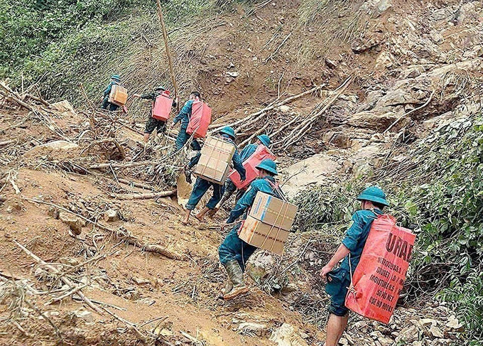 Các lực lượng cõng nhu yếu phẩm cần thiết vượt núi, băng rừng, lội suối vào tiếp tế cho các hộ xã biên giới Yên Nhân (Thanh Hóa) bị sạt lở cô lập.Ảnh: TTXVN phát mo-duong-6.jpg