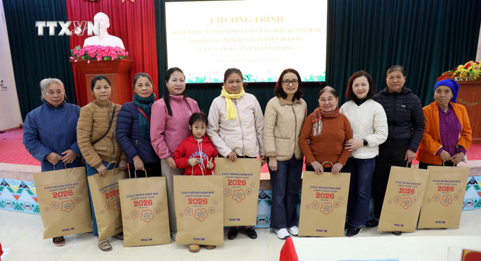 Cán bộ, nhân viên Văn phòng TTXVN với các gia đình được nhận quà tặng.