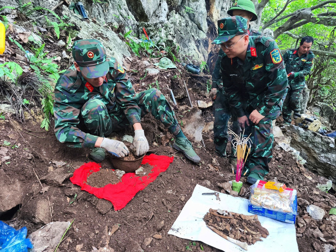 Trung tá Nguyễn Trung Kiên, Phó Chủ nhiệm Chính trị, Bộ Chỉ huy Quân sự tỉnh Hà Giang, trực tiếp chỉ đạo cất bốc 4 bộ hài cốt liệt sĩ vừa được tìm thấy tại khu vực Điểm cao 211. Ảnh: TTXVN phát hai-cot-3.jpg