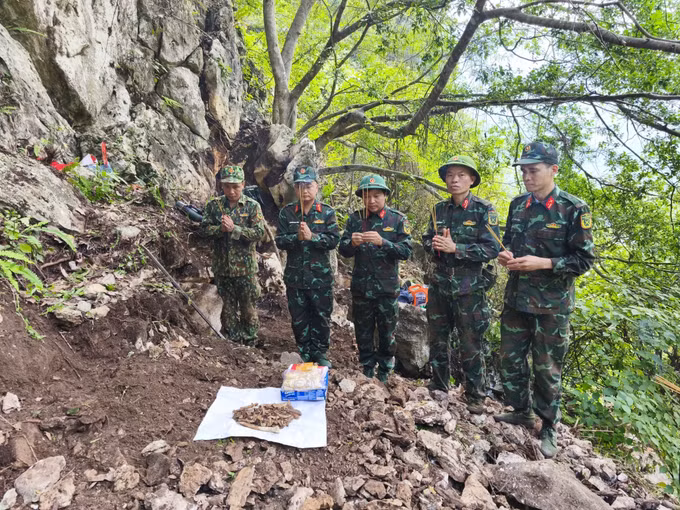 Đội tìm kiếm, quy tập hài cốt liệt sĩ thắp hương tưởng niệm khi vừa phát hiện một hài cốt liệt sĩ tại khu vực Điểm cao 211. Ảnh: TTXVN phát