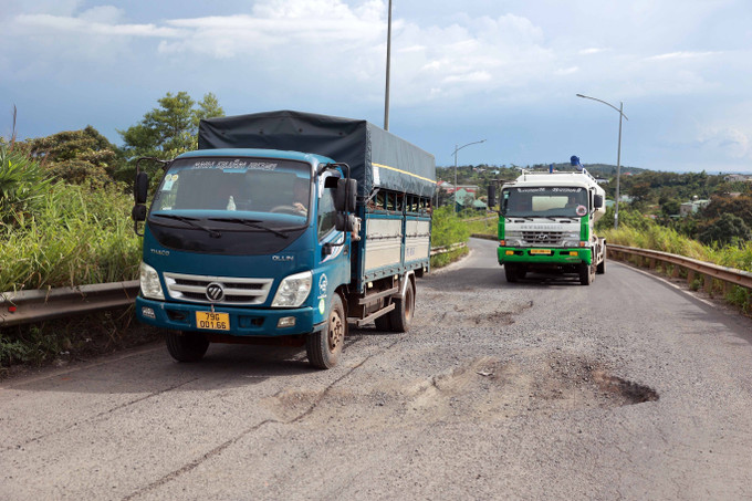 Nhiều xe tải trọng lớn di chuyển sang làn đối diện để né ổ voi, ổ gà trên tuyến. Nhiều xe tải trọng lớn di chuyển sang làn đối diện để né ổ voi, ổ gà trên tuyến.