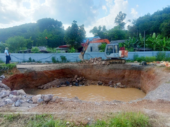 Đơn vị thi công tiến hành thả đá hộc xuống hố. Ảnh TTXVN phát ho-tu-than-2.jpg