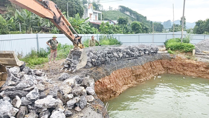 Đơn vị thi công đang làm rọ đá để thả xuống "hố tử thần". Ảnh TTXVN phát Đơn vị thi công đang làm rọ đá để thả xuống "hố tử thần". Ảnh TTXVN phát