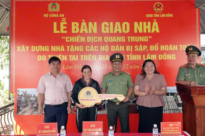 Đại tá Nay Gia Phú, Phó Giám đốc Công an tỉnh Lâm Đồng trao căn nhà mới hoàn thành cho gia đình chị Nguyễn Thị Hương Lan. Ảnh: TTXVN phát