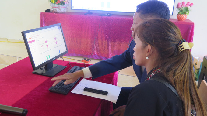 Hướng dẫn người dân thôn Suối Chải, xã Bát Xát thực hiện nộp hồ sơ trực tuyến trên cổng dịch vụ công. Ảnh: Hương Thu/TTXVN