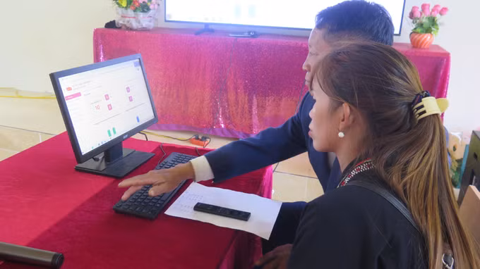 Hướng dẫn người dân thôn Suối Chải, xã Bát Xát thực hiện nộp hồ sơ trực tuyến trên cổng dịch vụ công. Ảnh: Hương Thu/TTXVN