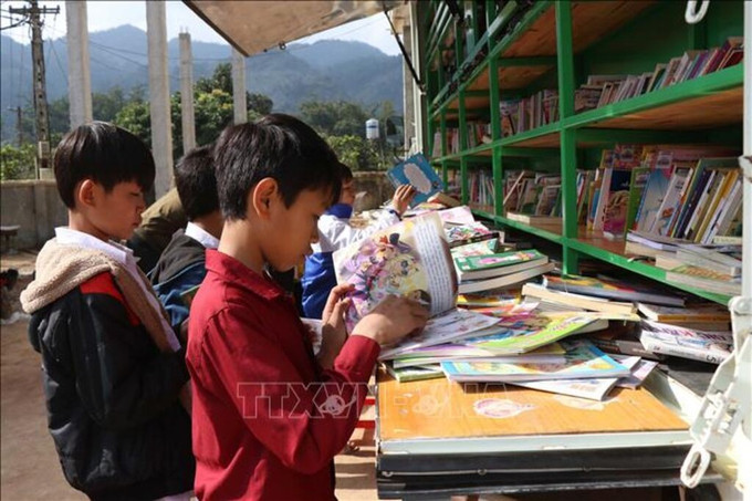 Các em học sinh vùng cao Sơn La được tiếp cận với nhiều loại sách báo bổ ích thông qua xe thư viện lưu động. Ảnh: Hữu Quyết/TTXVN thu-vien-230725.jpg