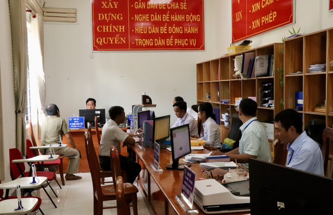 Cán bộ Trung tâm phục vụ hành chính công xã Mỹ Hoà Hưng, tỉnh An Giang giải quyết thủ tục hành chính cho người dân. an-giang-170725.jpg