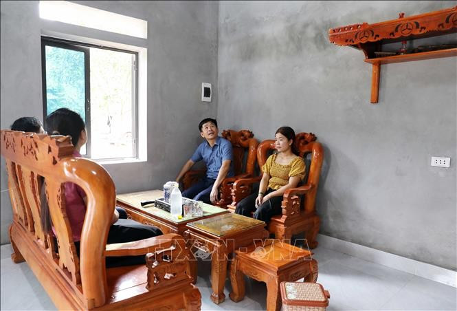 Gia đình anh Triệu Văn Kim, khu Thành Công, xã Văn Miếu trong ngôi nhà vừa được hỗ trợ xây mới. Ảnh: Tạ Toàn/TTXVN ts3-120525.jpg