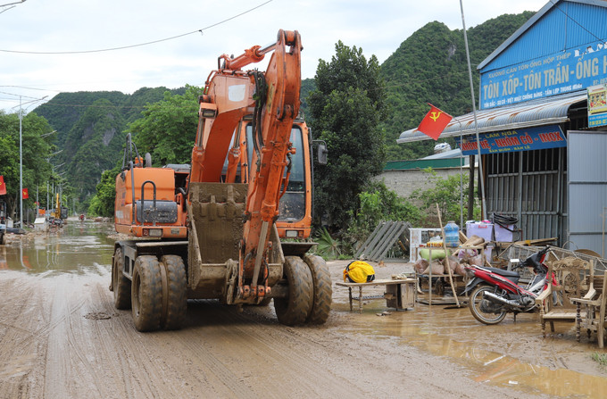 Máy cẩu được huy động tham gia giải phóng các điểm ngập trên quốc lộ 7. Ảnh: Xuân Tiến/TTXVN nghe-an2-250725.jpg