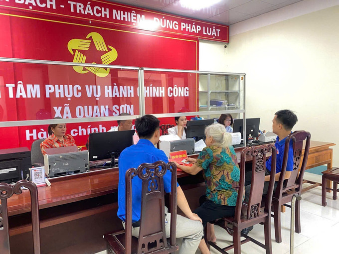 Đoàn viên thanh niên tỉnh Thanh Hóa hỗ trợ người dân làm thủ tục tại Trung tâm phục vụ hành chính công xã Quan Sơn. Ảnh: TTXVN phát thanh-hoa-0707.jpg