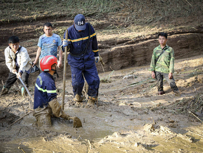 Trưởng bản Mùa A Thi (ngoài cùng bên phải) cùng lực lượng chức năng tìm kiếm các nạn nhân mất tích do sạt lở, lũ quét ở bản Háng Pu Xi, xã Xa Dung. Ảnh: Xuân Tư/TTXVN truong-ban3-040825.jpg