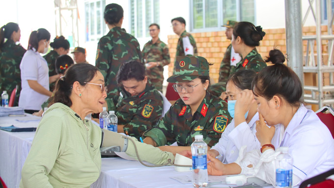 Lực lượng quân y của Quân đội nhân dân Việt Nam đo huyết áp cho người dân trước trước khi thăm khám.