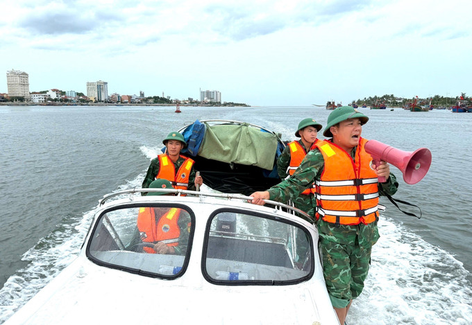 Cán bộ, chiến sỹ Đồn Biên phòng Nhật Lệ thông báo, kêu gọi, kiểm tra phương tiện tàu thuyền khẩn trương vào neo đậu tránh trú bão, đảm bảo an toàn. Ảnh: TTXVN phát quang-tri-210725.jpg