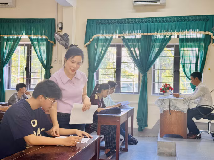 Giáo viên tại điểm thi Trường THPT Chuyên Hà Tĩnh hướng dẫn thí sinh đối chiếu thông tin cá nhân, đính chính sai sót (nếu có).