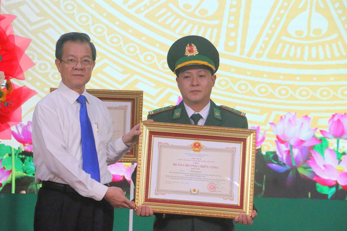 Thừa uỷ quyền của Chủ tịch nước, Bí thư Tỉnh uỷ An Giang Lê Hồng Quang trao tặng Huân chương Chiến công hạng Nhì cho Trung tá Võ Huy Hoàng, Đồn trưởng Đồn biên phòng Vĩnh Nguơn (Bộ đội Biên phòng An Giang). Ảnh: Công Mạo/TTXVN ag5-170625.jpg