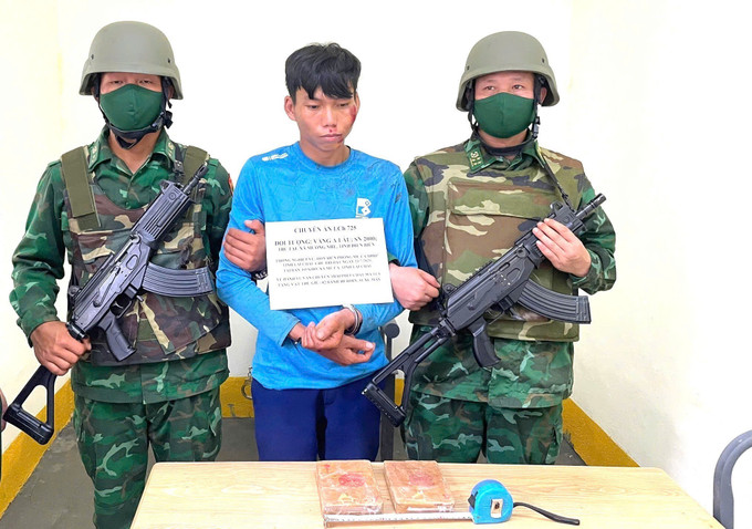Đối tượng Vàng A Lâu và tang vật thu giữ là 2 bánh heroin. Ảnh: TTXVN phát lai-chau-210725.jpg