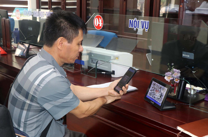 Người dân sử dụng điện thoại thông minh để quét QR-Code thực hiện các thủ tục hành chính. Ảnh: Văn Tý/TTXVN nghe-an5-210725.jpg