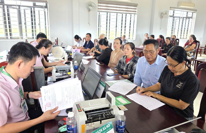 Phòng Giao dịch Ngân hàng Chính sách xã hội Quảng Trạch (tỉnh Quảng Trị) hỗ trợ, hướng dẫn người dân thực hiện các thủ tục vay vốn để tái thiết sản xuất, ổn định cuộc sống sau thiên tai. Ảnh: TTXVN phát