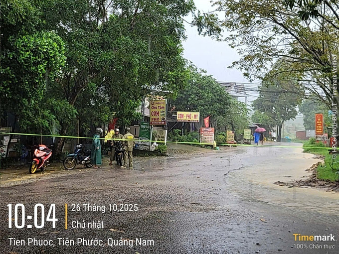Lực lượng chức năng canh giữ tại các vị trí nước băng qua đường để phòng ngừa rủi ro. Ảnh: Mạnh Thường/CTV da-nang3-2610.jpg