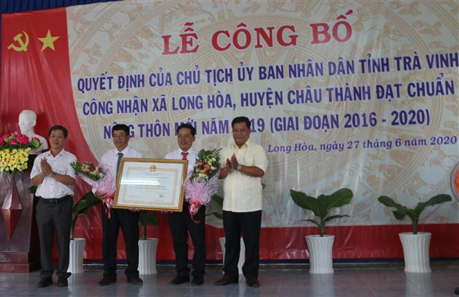 Lãnh đạo xã Long Hoà đón nhận Quyết định đạt chuẩn nông thôn mới. Ảnh: Thanh Hoà- TTXVN