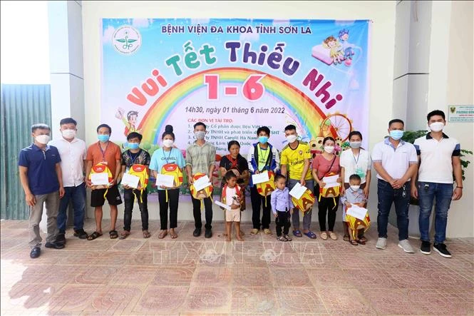 Tặng quà cho người thân và các bệnh nhi mắc bệnh hiểm nghèo, có hoàn cảnh khó khăn đang điều trị tại bệnh viện. Ảnh: Quang Quyết-TTXVN