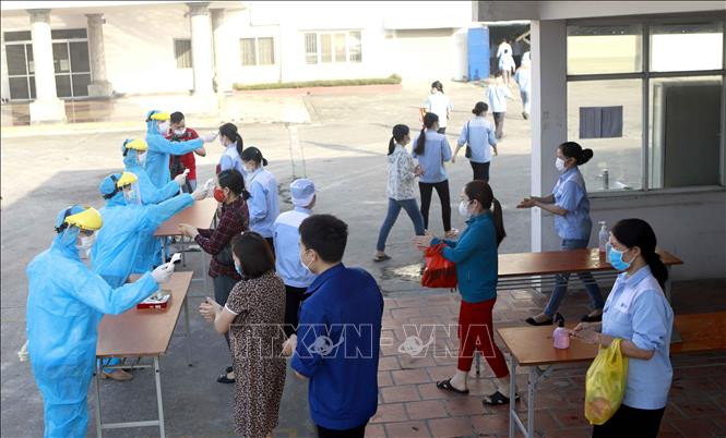 Đo thân nhiệt cho công nhân tại công ty TNHH KOHSEI MULTIPACK Việt Nam, khu công nghiệp Bình Xuyên. Ảnh: Hoàng Hùng -TTXVN