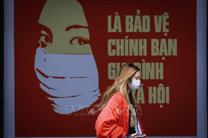Bộ Y tế khuyến cáo người dân, kể cả những người đã tiêm vaccine, tiếp tục thực hiện thông điệp 5K, đặc biệt là đeo khẩu trang, giữ khoảng cách, hạn chế tiếp xúc. Ảnh: Thành Đạt - TTXVN