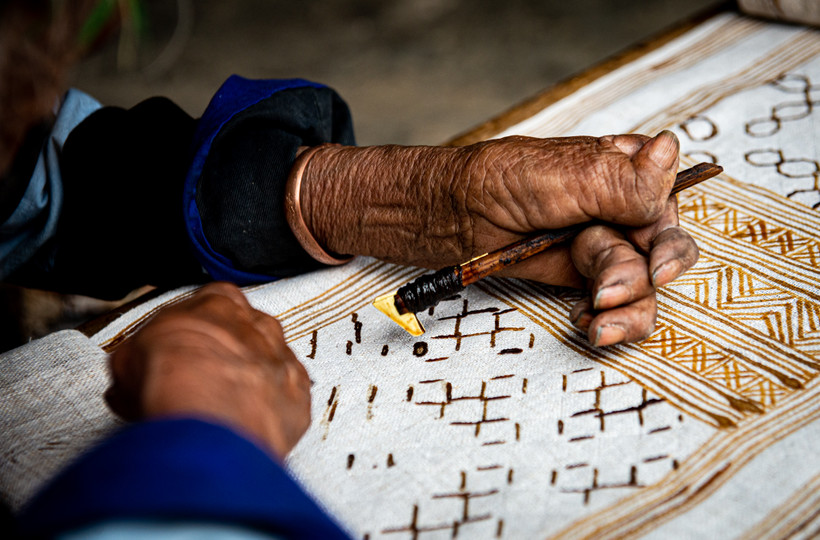 Nghệ nhân vẽ sáp ong lên vải lanh. Ảnh:Nam Thái