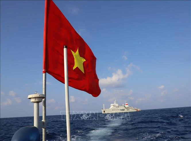 Cờ Tổ quốc tung bay trên nóc xuồng máy chở cán bộ, chiến sỹ từ tàu Trường Sa 571 lên đảo Song Tử Tây. Ảnh: Sỹ Tuyên – TTXVN