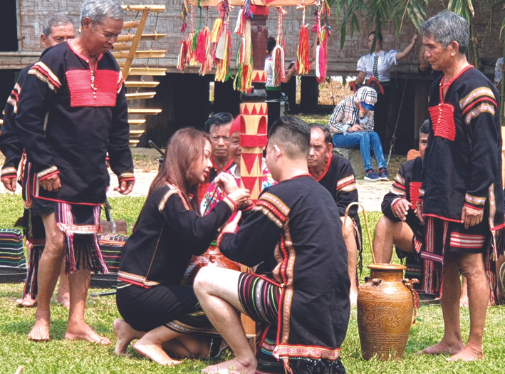 Từng người trong dòng họ đeo vòng cho chủ nhà để gửi gắm tình cảm quý mến, yêu thương, gắn kết cộng đồng. Ảnh: Hoàng Hải