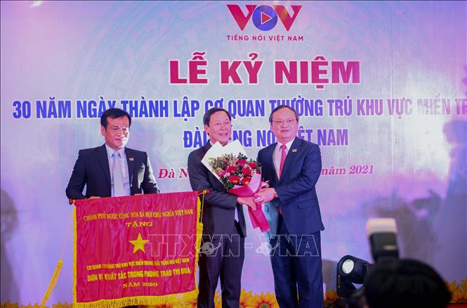 Thừa ủy quyền Thủ tướng Chính phủ, đồng chí Đỗ Tiến Sỹ, Ủy viên Trung ương Đảng, Bí thư Đảng ủy, Tổng Giám đốc Đài Tiếng nói Việt Nam trao Cờ thi đua của Chính phủ tặng cho tập thể Cơ quan thường trú Khu vực miền Trung. Ảnh: Trần Lê Lâm – TTXVN