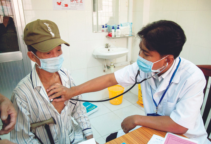 Bác sĩ Danh Ngọc Châu khám bệnh cho người dân có hoàn cảnh khó khăn tại phòng khám Trung tâm Y tế huyện Châu Thành. Ảnh: Hồng Đạt