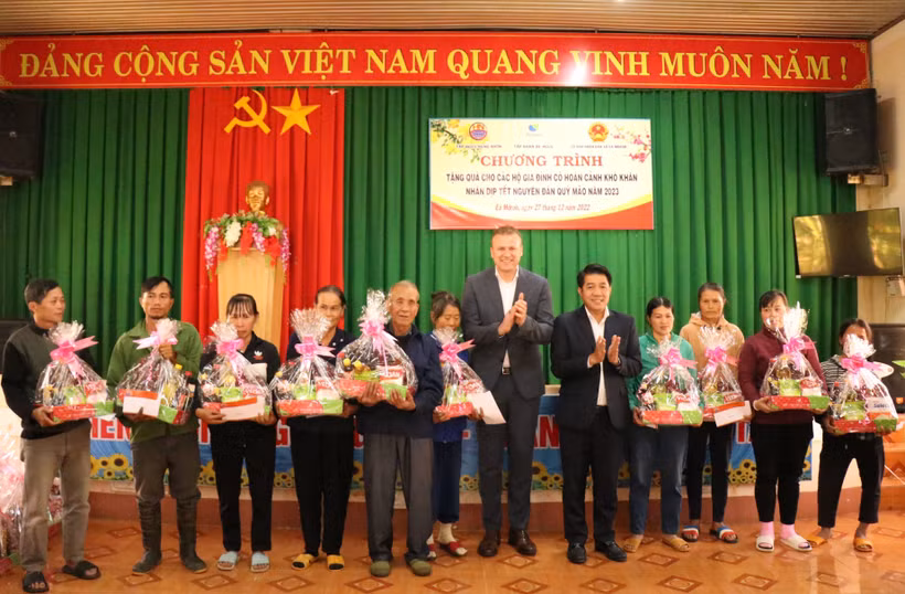 Đại diện doanh nghiệp tặng quà Tết cho người dân. Ảnh: Tuấn Anh - TTXVN