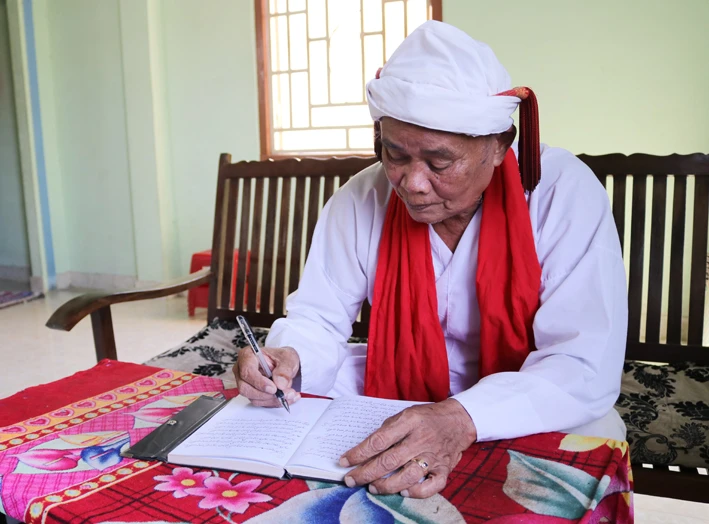 Cả sư Đổng Bạ biên tập các phong tục, nghi lễ truyền thống bằng tiếng Chăm. Ảnh: Nguyễn Thành