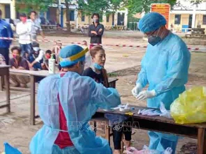 Kiểm tra sức khỏe cho người dân đang được cách ly theo quy định tại Khu cách ly tập trung thị trấn An Phú, huyện An Phú. Ảnh: Phạm Hậu - TTXVN
