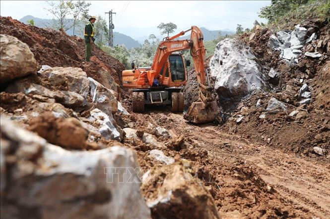 Khẩn trương san lấp, khắc phục tình trạng sạt lở đường dẫn vào xã Trường Sơn. Ảnh: Danh Lam – TTXVN