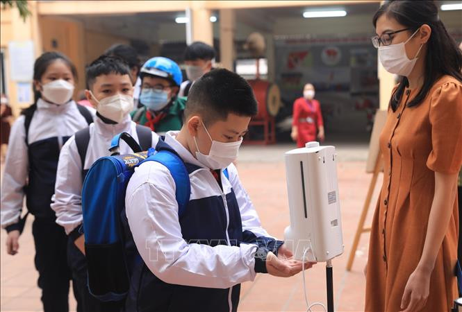  Học sinh khối lớp 6 đo thân nhiệt và sát khuẩn tay trong ngày đầu tiên đến Trường THCS Quỳnh Mai, quận Hai Bà Trưng. Ảnh: Hoàng Hiếu - TTXVN