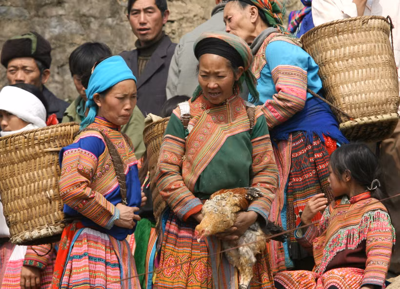 Đồng bào dân tộc đi chợ giáp Tết chỉ với con gà cắp nách. Ảnh: Xuân Chính