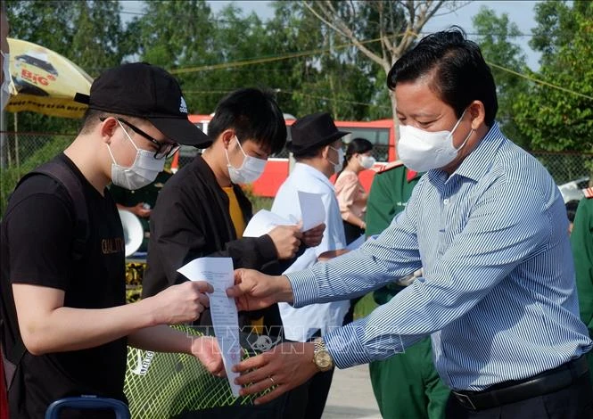 Phó Chủ tịch UBND tỉnh Long An Phạm Tấn Hòa trao giấy xác nhận hoàn thành thời gian cách ly cho các công dân. Ảnh: Đức Hạnh - TTXVN