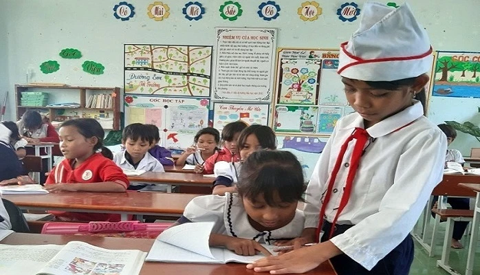 Katơr Thị Y hướng dẫn các em nhỏ học tập. Ảnh: Công Thử - TTXVN