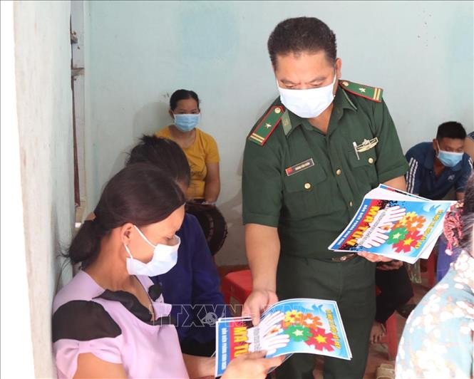 Cán bộ Đồn Biên phòng Bình Nghi (Lạng Sơn) phát tờ rơi tuyên truyền pháp luật cho người dân vùng biên giới. Ảnh: Quang Duy – TTXVN