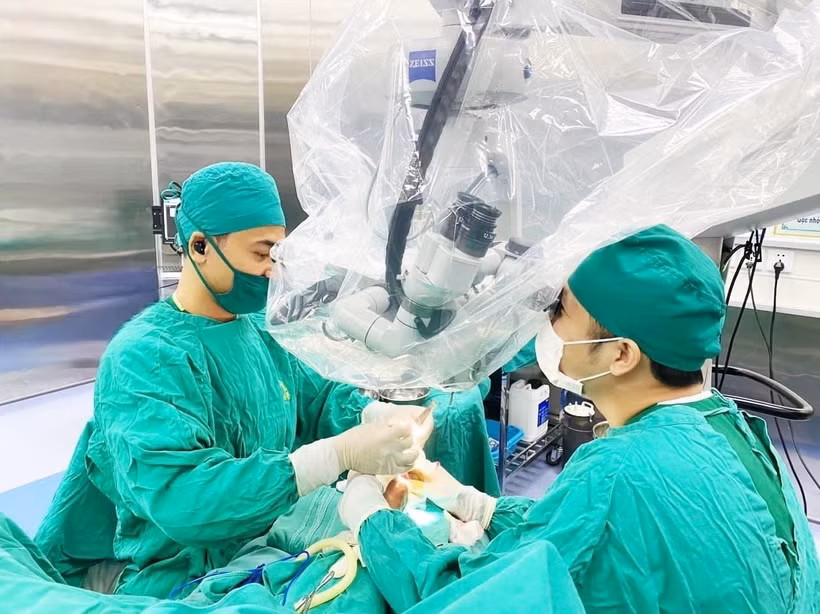 Ê-kíp bác sỹ bệnh viện Đa khoa tỉnh Thanh Hóa đã xuyên đêm tiến hành phẫu thuật nối cẳng chân đứt rời cho bệnh nhân bằng kính vi phẫu. Ảnh: TTXVN phát